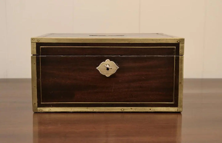 Front view of antique campaign writing box with brass trim and escutcheon.