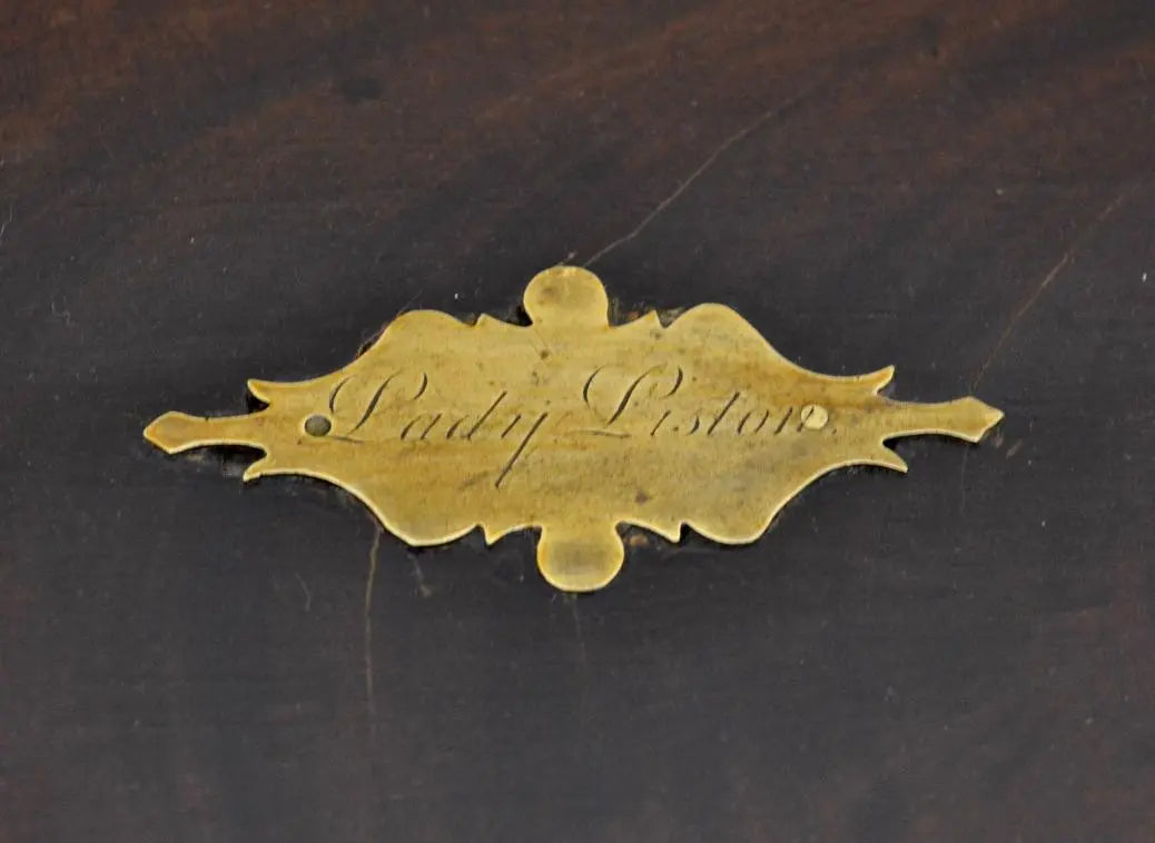 Close-up of engraved brass plaque reading "Lady Liston" on writing box lid.