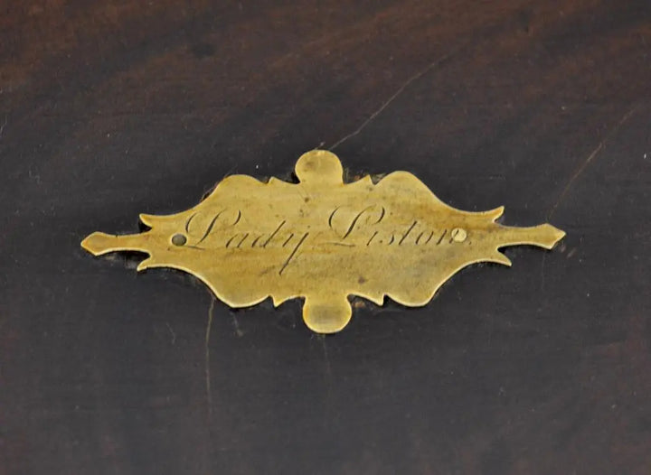 Close-up of engraved brass plaque reading "Lady Liston" on writing box lid.