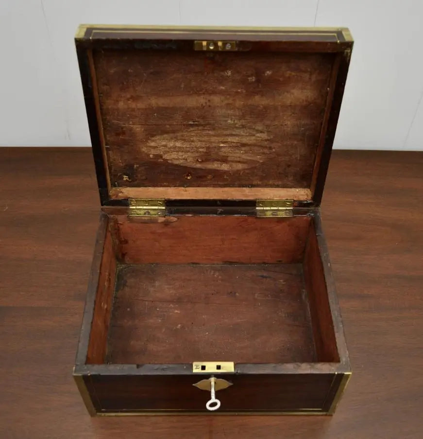 Interior view of antique brass-bound writing box with key.