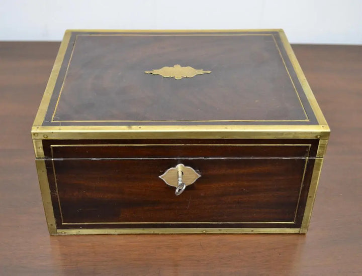 Top view of vintage writing box showing inlaid brass plaque and keyhole.