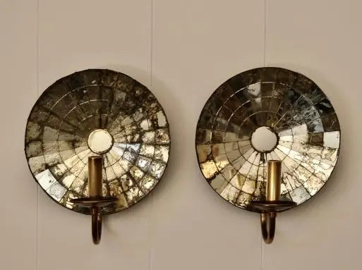 Pair of antique mirrored glass wall sconces with brass candle holders mounted 