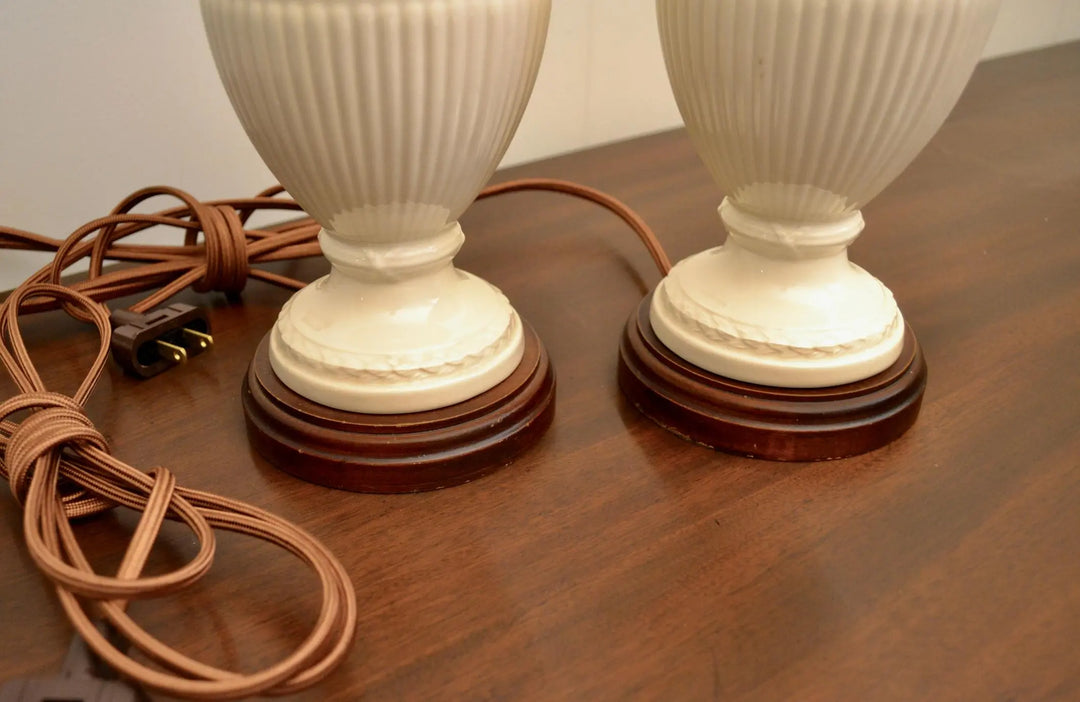 Detailed view of vintage ceramic lamp bases with wood stands and fabric-covered power cords.