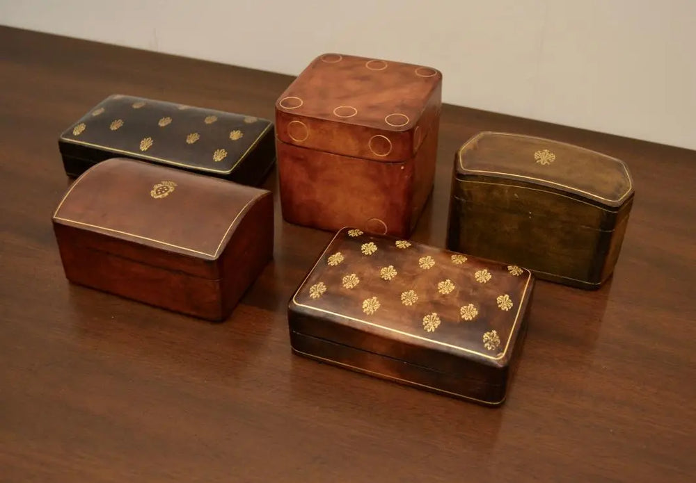 Assorted vintage Japanese lacquer boxes with gold circular and floral designs viewed from an elevated angle.