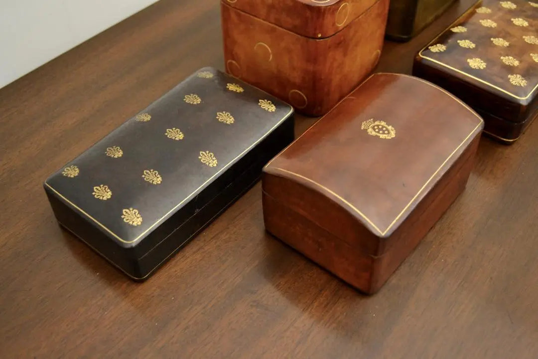 Close-up of two Japanese lacquered boxes with gold crest and floral motifs