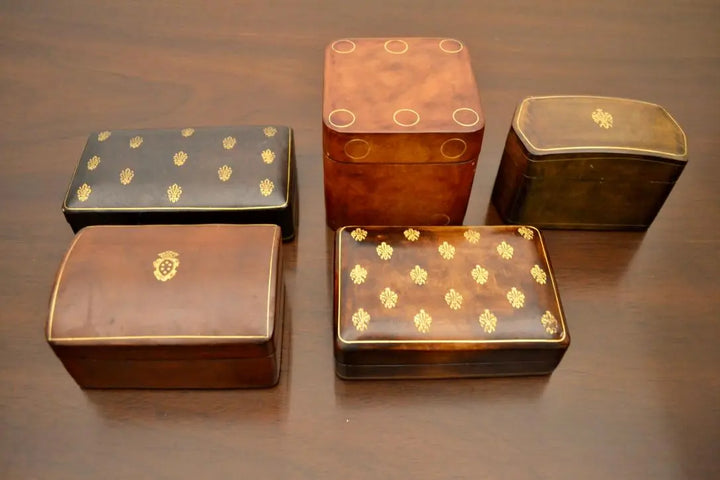  Top-down view of five Japanese-style lacquered boxes with intricate gold detailing and curved lids.