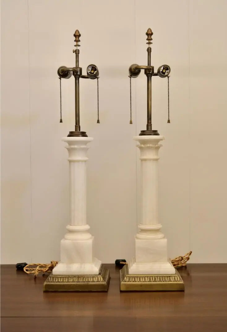 Pair of vintage neoclassical white marble column table lamps with brass accents and dual pull chains.