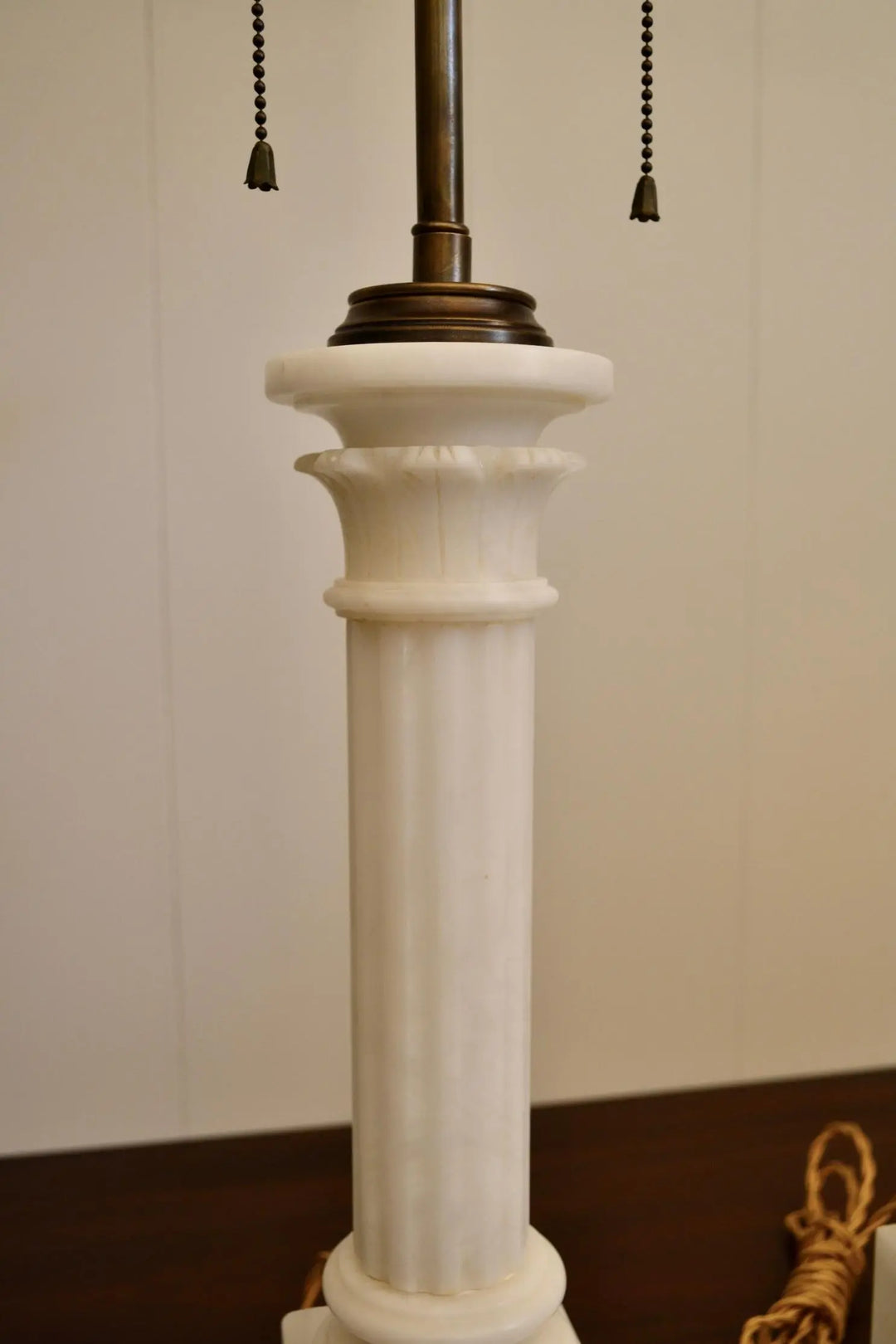 Detailed view of the fluted white marble column and ornate capital of a vintage table lamp.