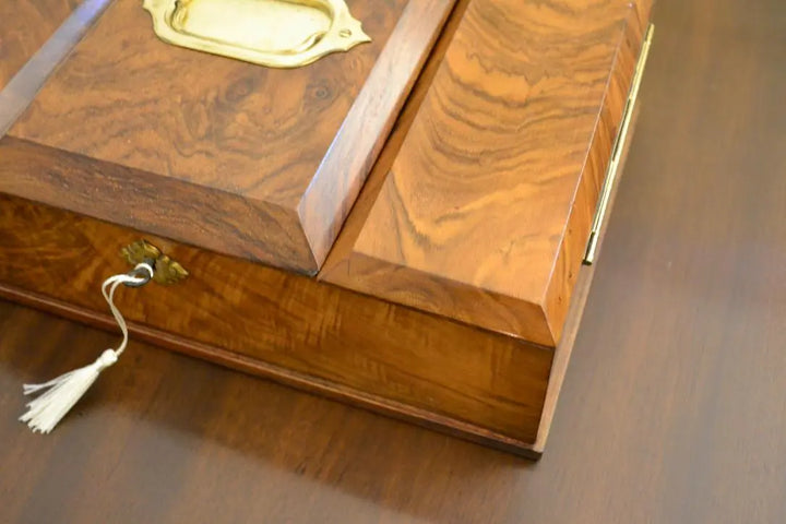 Close-up of antique walnut tea caddy box showing detailed wood grain and brass hinge