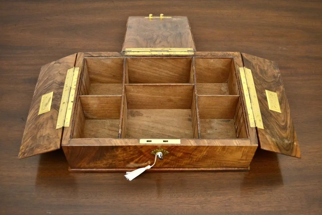 Open antique tea caddy box with multiple wooden compartments and brass hinges