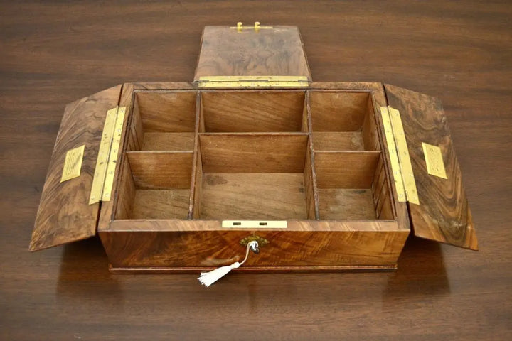 Open antique tea caddy box with multiple wooden compartments and brass hinges
