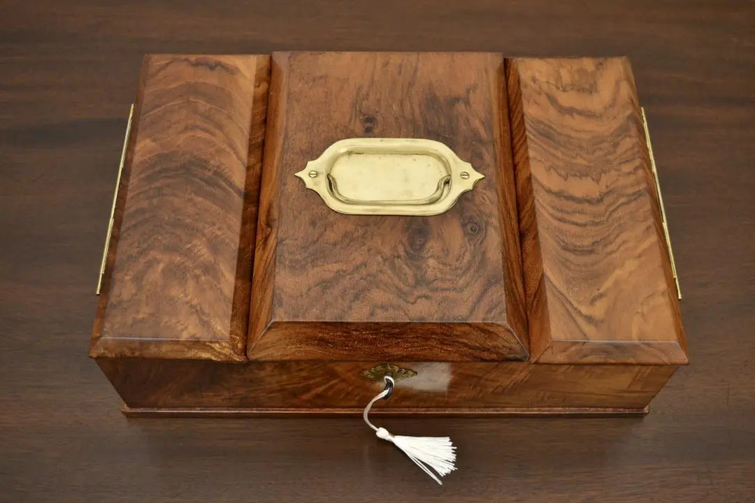 Overhead view of antique walnut tea caddy featuring central brass handle and rich wood texture