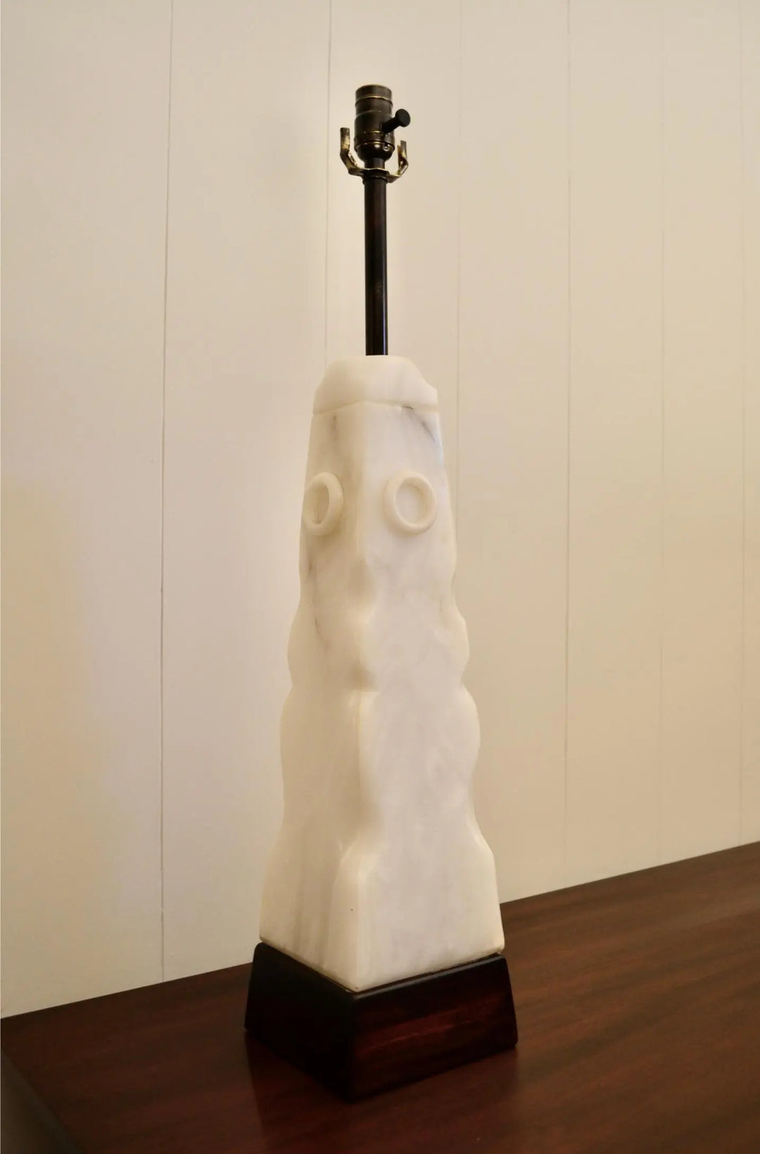Angled view of white alabaster lamp showing geometric shape and metal socket.