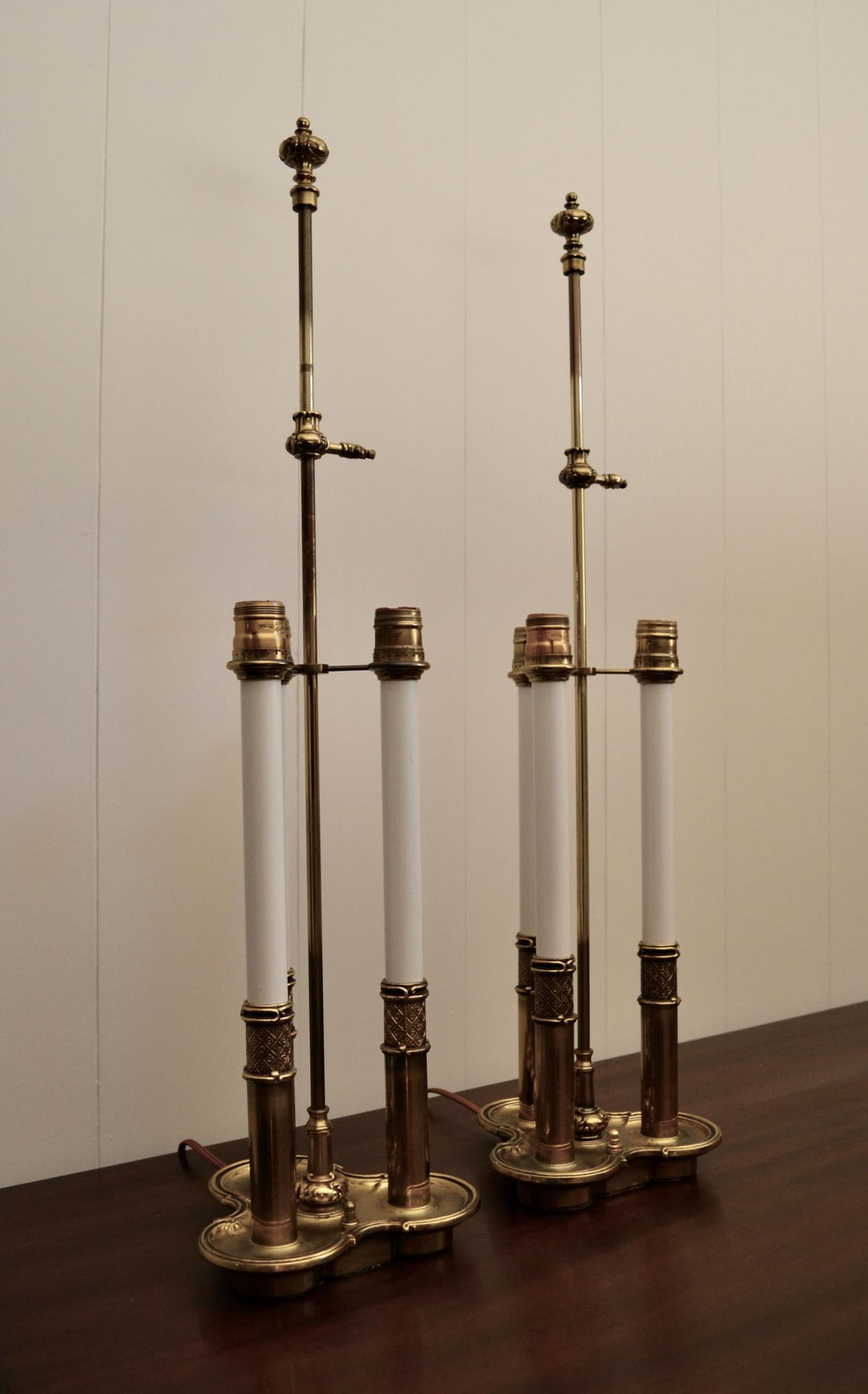 Pair of antique brass taper candle holders with burgundy candles