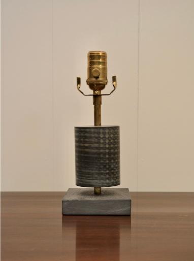 Front view of compact table lamp with slate base, ribbed black body, and brass socket