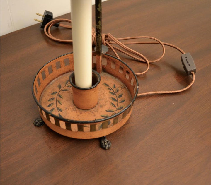 Close-up of Bouillotte lamp’s base showing circular tray with painted olive leaf wreath and paw feet