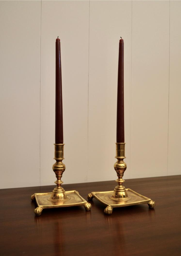 Brass candlestick holders with tall burgundy taper candles