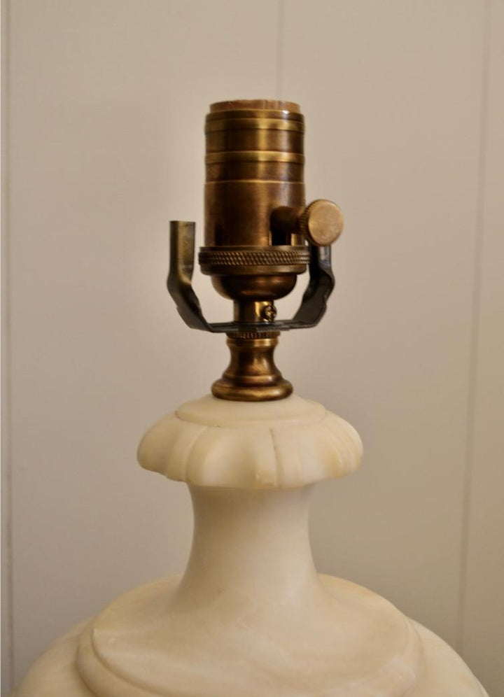 Close-up of vintage brass socket on white alabaster urn lamp with fluted neck detailing