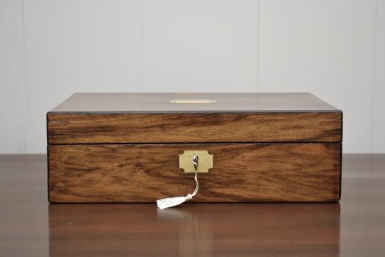 ront view of closed antique mahogany jewelry box with key and brass lock plate