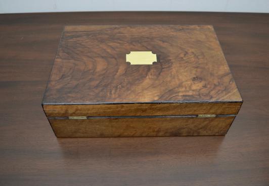 Top view of closed antique mahogany jewelry box featuring brass inlay detail