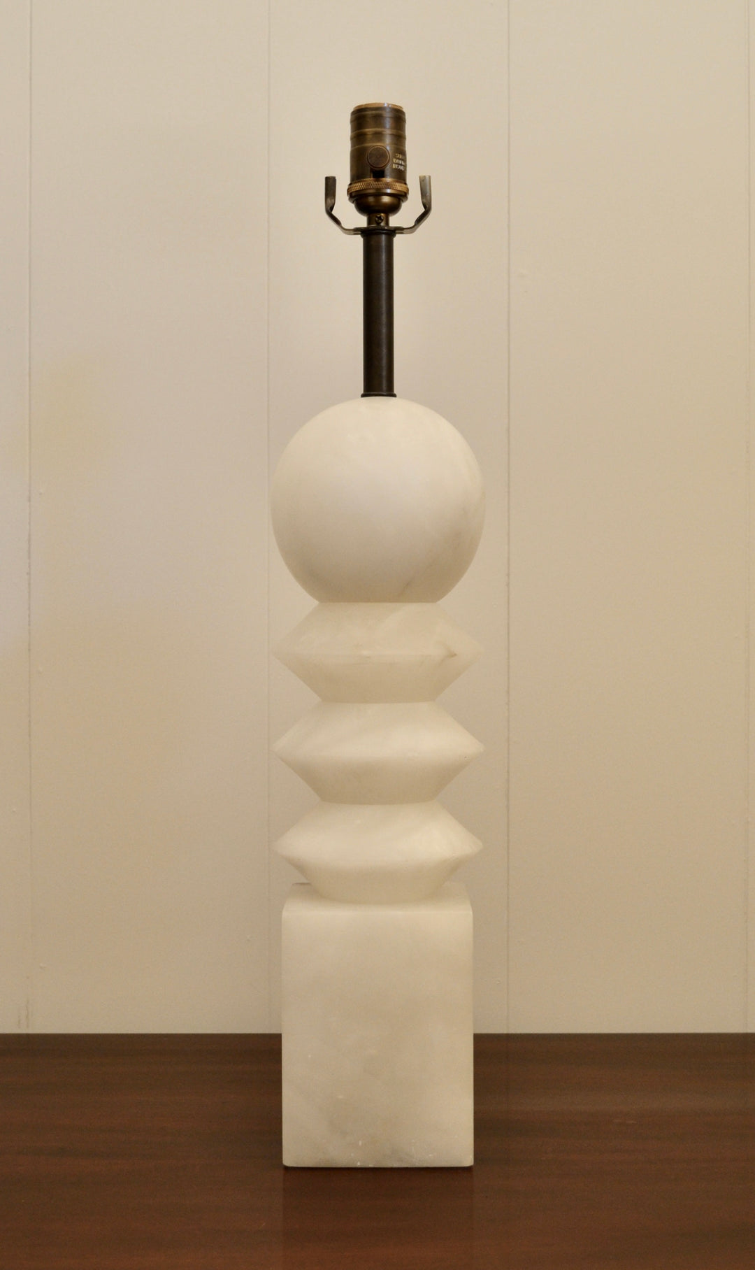 Mid-century modern alabaster table lamp with stacked geometric shapes and brass socket, displayed against a neutral background.