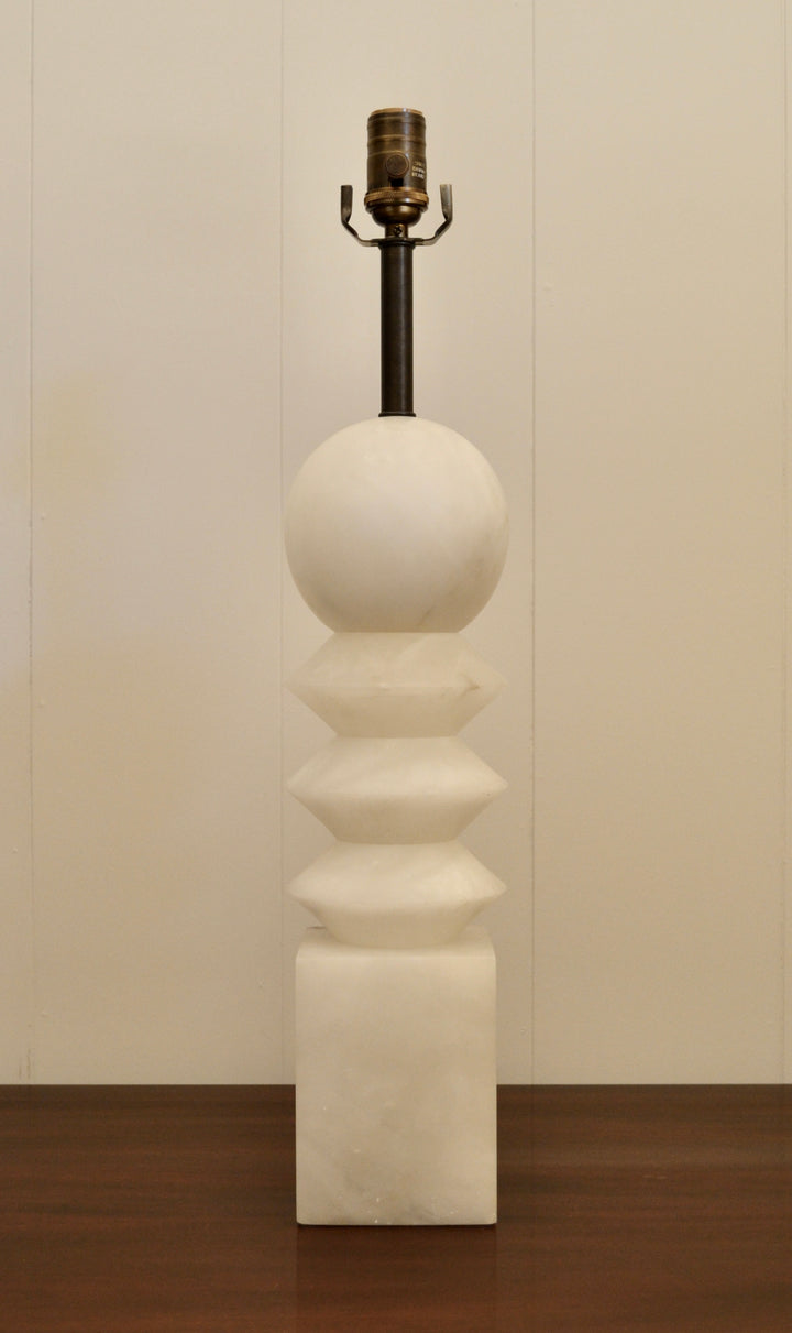 Mid-century modern alabaster table lamp with stacked geometric shapes and brass socket, displayed against a neutral background.
