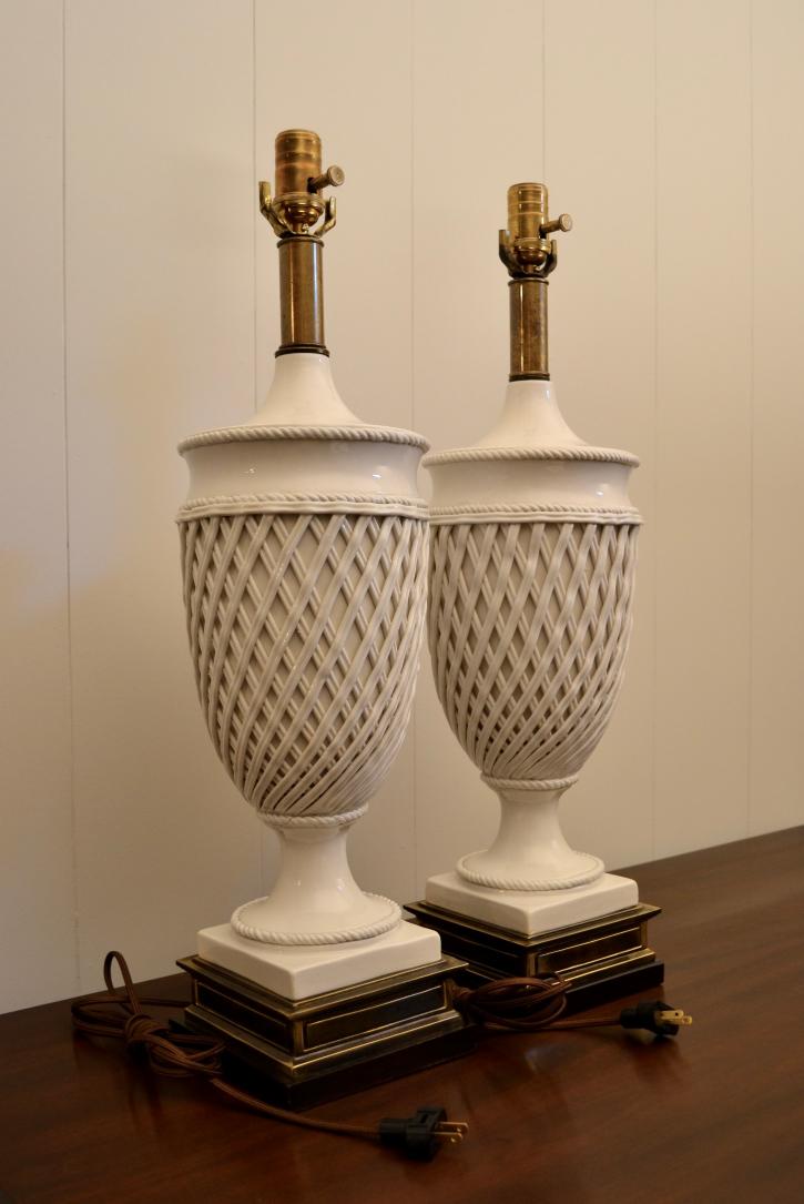 Side angle view of a pair of white ceramic urn table lamps by Frederick Cooper with lattice design and brass bases.