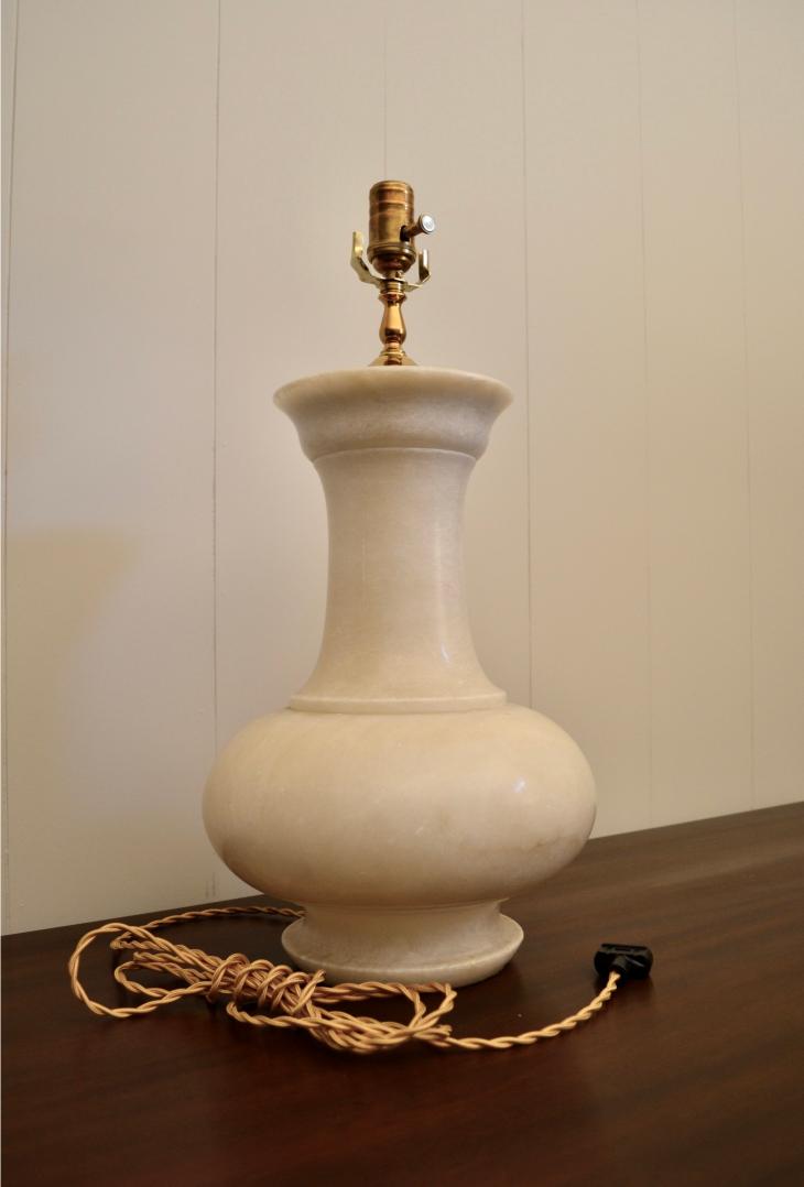 Side view of vintage alabaster table lamp with bulb socket and braided power cord