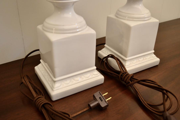 Bottom view of vintage white ceramic table lamp bases with brown electric cords and two-prong plugs